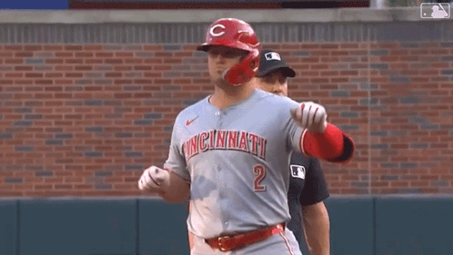 A Baseball Player Wearing A Cincinnati Jersey Is Standing On A Baseball Field . GIF