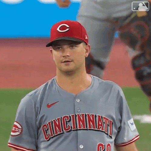 A Baseball Player Wearing A Cincinnati Jersey Is Standing On The Field . GIF