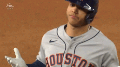 A Baseball Player Wearing A Helmet And A Houston Jersey Is Standing On A Field . GIF