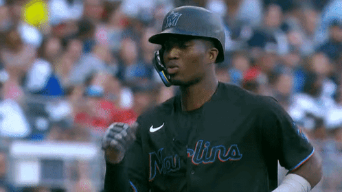 A Baseball Player Wearing A Helmet And A Jersey That Says ' Mariners ' On It . GIF