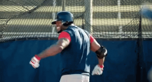 a baseball player wearing a helmet and gloves is swinging his bat