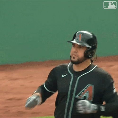 A Baseball Player Wearing A Helmet And Gloves Stands On A Field GIF