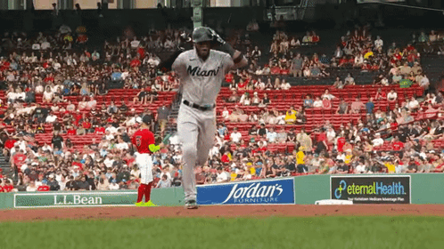 A Baseball Player Wearing A Miami Jersey Is Running Towards The Base GIF