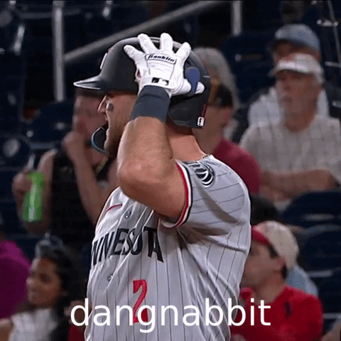 A Baseball Player Wearing A Minnesota Jersey Holds His Helmet Up GIF