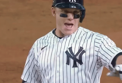 A Baseball Player Wearing A New York Yankees Uniform Is Standing On A Field . GIF