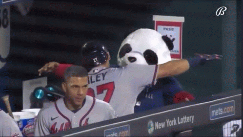 A Baseball Player Wearing A Number 27 Jersey Is Being Hugged By A Panda Mascot GIF