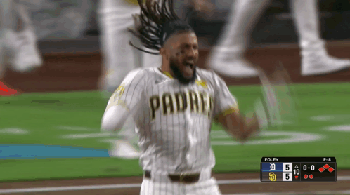 A Baseball Player Wearing A Padres Jersey Is Celebrating On The Field GIF