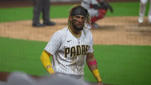 A Baseball Player Wearing A Padres Jersey Is Standing On A Field . GIF
