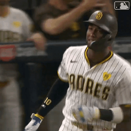 A Baseball Player Wearing A Padres Uniform Is Swinging His Bat At A Pitch . GIF