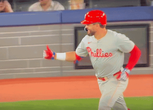 A Baseball Player Wearing A Phillies Jersey And A Red Helmet GIF