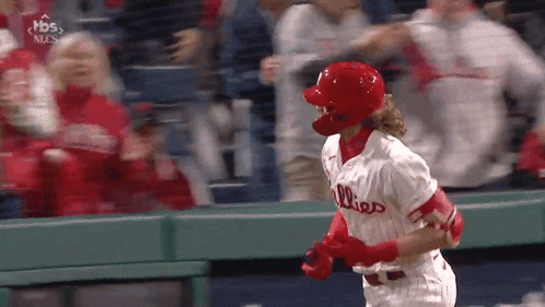 A Baseball Player Wearing A Phillies Jersey Is Running Towards The Dugout GIF