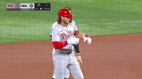 A Baseball Player Wearing A Phillies Jersey Stands On A Field GIF