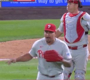A Baseball Player Wearing A Phillies Jersey Stands On The Field GIF