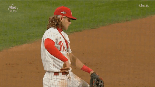 A Baseball Player Wearing A Phillies Uniform Is Kneeling On The Field GIF