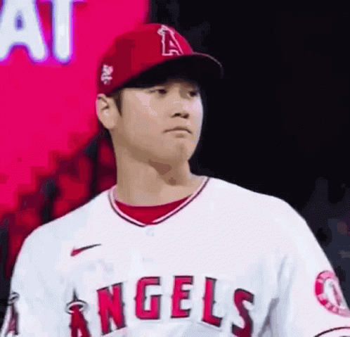 A Baseball Player Wearing A Red Hat And A White Jersey Is Standing In Front Of A Red Background . GIF