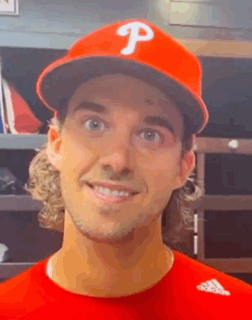a baseball player wearing a red hat with the letter p on it