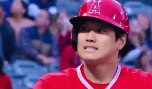 A Baseball Player Wearing A Red Helmet And A Red Shirt Is Standing In Front Of A Crowd At A Baseball Game . GIF