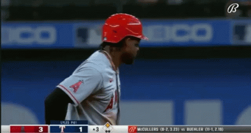 A Baseball Player Wearing A Red Helmet Stands In Front Of A Scoreboard That Says ' Lyles Pai ' On It GIF