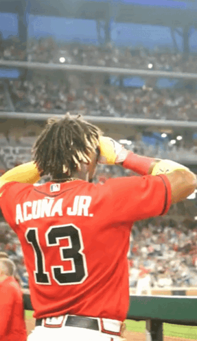 A Baseball Player Wearing A Red Jersey With The Number 13 On The Back GIF