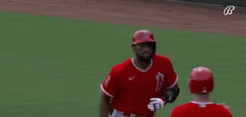 A Baseball Player Wearing A Red Jersey With The Number 5 On It Is Talking To Another Player On The Field . GIF