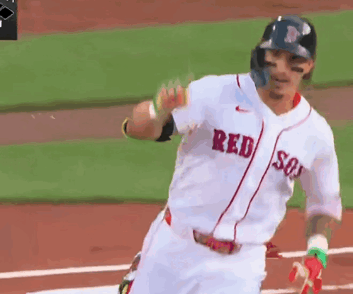 a baseball player wearing a red sox jersey is running towards home plate
