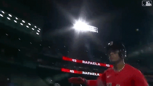 A Baseball Player Wearing A Red Sox Jersey Is Standing Next To Another Player In A Dark Stadium . GIF