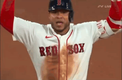 A Baseball Player Wearing A Red Sox Jersey Is Standing On A Field With His Arms In The Air . GIF