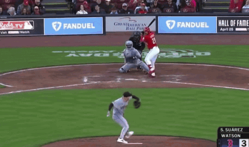 a baseball player wearing a reds jersey is standing on the field
