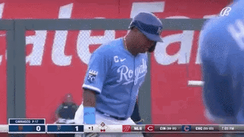 A Baseball Player Wearing A Royals Jersey Is Standing On The Field . GIF