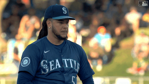 A Baseball Player Wearing A Seattle Jersey And A Hat GIF
