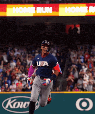 A Baseball Player Wearing A Usa Jersey Is Running Towards Home Plate GIF
