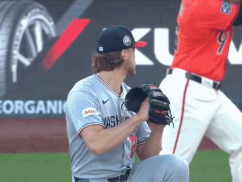 A Baseball Player Wearing A Washington Jersey Is Kneeling Down GIF