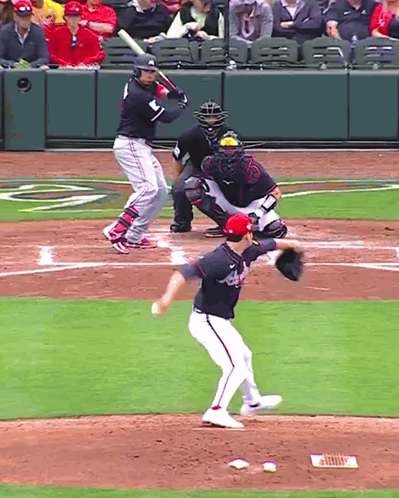 A Baseball Player Wearing A Washington Nationals Jersey Is About To Swing At A Pitch GIF