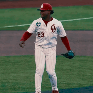 a baseball player wearing a white jersey with a red letter l on it