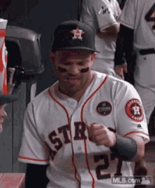 a baseball player wearing a white jersey with the number 2 on it