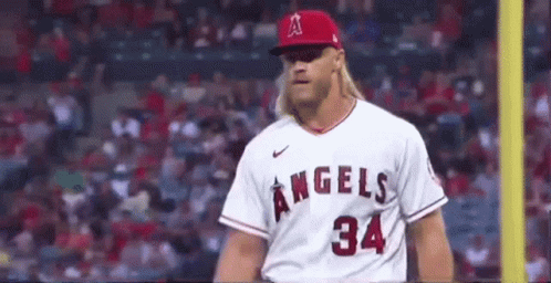 A Baseball Player Wearing A White Jersey With The Number 34 On It Is Standing On A Field . GIF