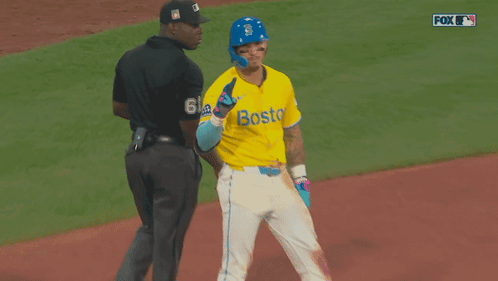 a baseball player wearing a yellow jersey with boston on it