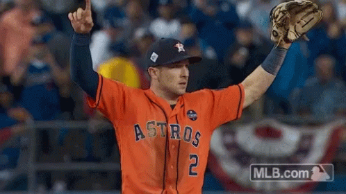 A Baseball Player Wearing An Orange Astros Jersey Holds His Glove Up In The Air GIF