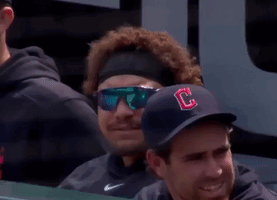 A Baseball Player Wearing Sunglasses And A Hat With The Letter C On It Blowing A Bubble GIF