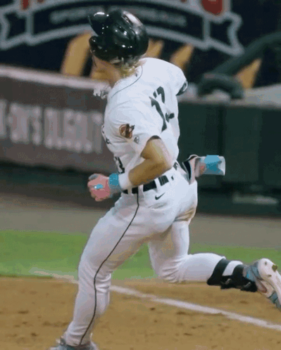 A Baseball Player With The Number 12 On His Jersey Is Running GIF