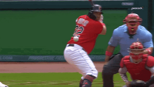 A Baseball Player With The Number 22 On His Back Swings At A Ball GIF