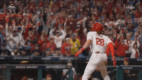 A Baseball Player With The Number 28 On His Back Is Standing On The Field . GIF