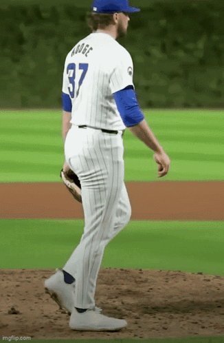 A Baseball Player With The Number 37 On His Back Is Walking On The Field GIF