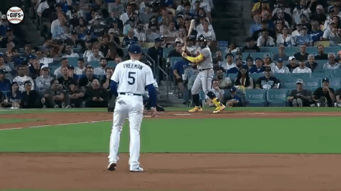 A Baseball Player With The Number 5 On His Jersey Is Swinging A Bat At A Ball . GIF