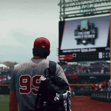 A Baseball Player With The Number 99 On His Back Walks On The Field GIF