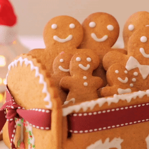 A Basket Filled With Gingerbread Men And Women With Smiley Faces On Them GIF