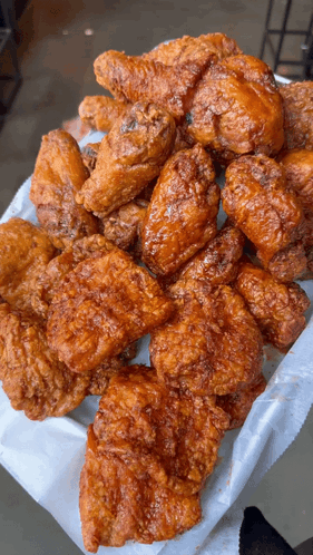 A Basket Of Fried Chicken Wings And Pieces Of Chicken GIF