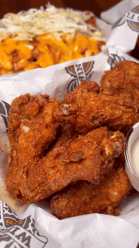 A Basket Of Fried Chicken Wings Sits On A Table GIF