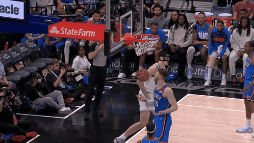 A Basketball Game Being Played In Front Of A State Farm Banner GIF
