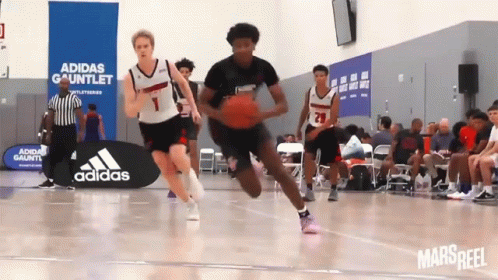 A Basketball Game Being Played In Front Of An Adidas Sign GIF